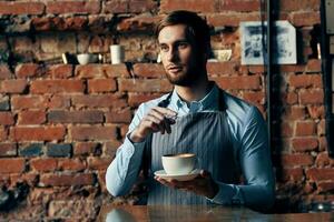 maschio Cameriere servizio un' tazza di caffè ordinazione professionale foto