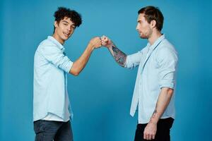 dai capelli ricci tipo nel un' camicia saluta il suo amico su un' blu sfondo foto