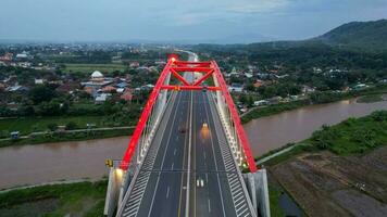 aereo Visualizza di il kalikuto ponte, un iconico rosso ponte a trans Giava Pedaggio strada, batang quando Alba. centrale Giava, Indonesia, dicembre 6, 2021 foto