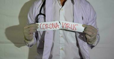 un' medico indossa un' Salute maschera e un' colpire carta corona virus isolato su bianca sfondo. foto