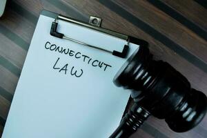 concetto di Connecticut legge Scrivi su lavoro d'ufficio isolato su di legno tavolo. foto