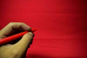 uomo mano con rosso penna scrittura su rosso sfondo foto
