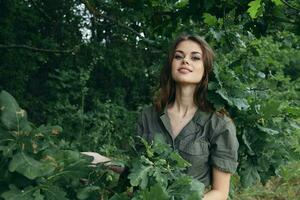 donna nel il foresta Sorridi verde le foglie natura sfondo fresco aria foto