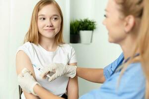 femmina medico dando un iniezione per il ragazze mano vaccinazione Salute foto