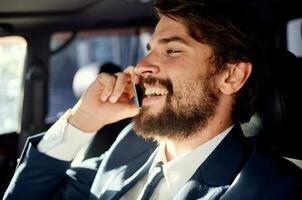 attività commerciale uomo con un' barba parlando su il Telefono nel un' auto viaggio foto