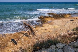 ombrellone abbandonato su una spiaggia rocciosa a ridosso del mare