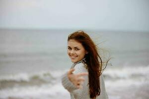 bellissimo donna rosso capelli nel un' maglione di il oceano stile di vita foto