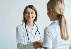 donna medico con bicchieri nel mani su un' leggero sfondo paziente comunicazione foto