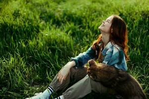 donna dire bugie su il erba sorridente giocando e coccole sua cane nel natura nel il parco nel il estate tramonto. il concetto di Salute e amore di animali, trattamento di zecche e pulci erba e animali foto