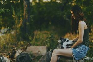 donna e sua rauco cane felicemente giocando all'aperto nel il parco tra il alberi Sorridi con denti nel il autunno camminare con sua animale domestico foto