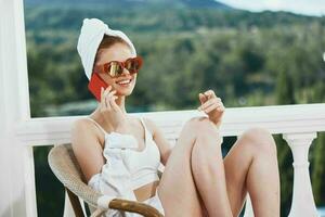 bellissimo donna seduta su il balcone parlando su il Telefono inalterato foto