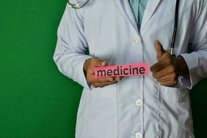medico in piedi su verde sfondo. hold il medicina carta testo. medico e assistenza sanitaria concetto. foto