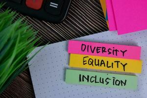 diversità uguaglianza inclusione Scrivi su un' appiccicoso Nota isolato su ufficio scrivania. foto