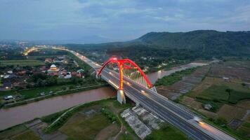 aereo Visualizza di il kalikuto ponte, un iconico rosso ponte a trans Giava Pedaggio strada, batang quando Alba. centrale Giava, Indonesia, dicembre 6, 2021 foto