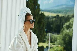 bellissimo donna in posa contro il fondale di montagne su il balcone architettura inalterato foto