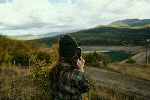 viaggiatore con un' mobile Telefono nel sua mani su natura nel autunno nel il montagne foto