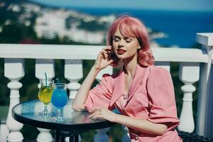 ritratto di bellissimo donna potabile un' cocktail su il terrazza estate giorno foto