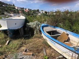 barche da pesca abbandonate e vuote in decomposizione in un campo erboso foto