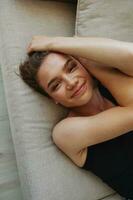 giovane donna con corto taglio di capelli capelli avendo divertimento a casa su il divano Sorridi e felicità, vacanza a casa, naturale in posa senza filtri, gratuito copia spazio foto