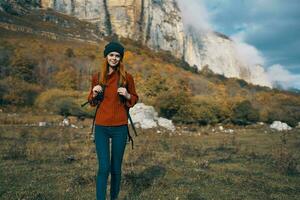 donna nel maglione tratti su sua mano per il telecamera all'aperto nel autunno viaggio turismo modello foto