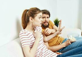 uomo e donna Guardando film in casa con Popcorn e fiore nel un' pentola foto