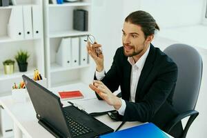 manager opera nel il ufficio nel davanti di un' il computer portatile tecnologie foto