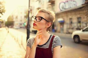 corto dai capelli donna indossare bicchieri all'aperto a piedi in posa foto