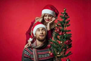 uomo e donna Natale albero decorazione divertimento vacanza rosso sfondo foto