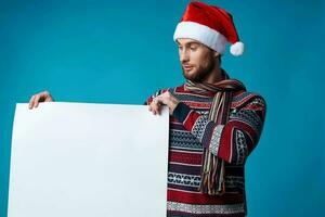 bello uomo nel un' Santa cappello Tenere un' bandiera vacanza blu sfondo foto