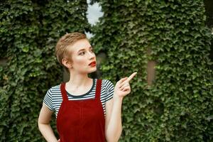 donna con corto capelli a piedi nel il parco un' tazza di caffè estate stile di vita foto