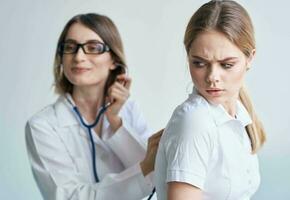 il paziente trasformato sua indietro per il medico nel un' medico toga con un' stetoscopio foto