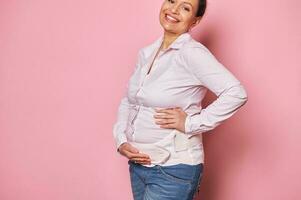 avvicinamento sorridente incinta donna indossare un' confortevole ortopedico bendare per ridurre dolore nel il indietro durante gravidanza foto