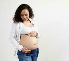 mezzo anziano bellissimo incinta donna aspettandosi bambino Tenere pancia godendo sua caferee contento gravidanza, bianca sfondo foto