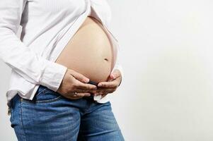 avvicinamento di spoglio pancia di incinta donna su bianca isolato sfondo. ginecologia Da donna Salute e fertilità. anno Domini spazio foto