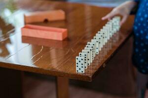 ragazzo giocando con domino, vicino su. costruire un' domino recinzione, vicino su foto