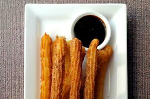 churros ciambelle spagnole con salsa al cioccolato fondente foto