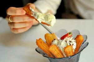 mangiare spagnolo churros immersione per vaniglia gelato di dita foto