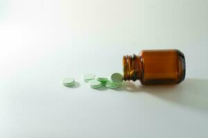 gruppo di medicina pillole e antibiotici, bianca medico compresse, leggero verde, nel Marrone bicchiere bottiglie, con copia spazio. foto