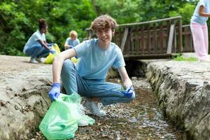 uomo raccolta manuale raccolta su spazzatura plastica cannucce spazzatura a partire dal il fiume a il parco. mondo ambiente giorno.ambiente concetto. foto