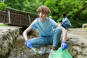 uomo raccolta manuale raccolta su spazzatura plastica cannucce spazzatura a partire dal il fiume a il parco. mondo ambiente giorno.ambiente concetto. foto