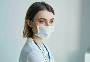 donna infermiera nel medico maschera blu stetoscopio leggero sfondo foto