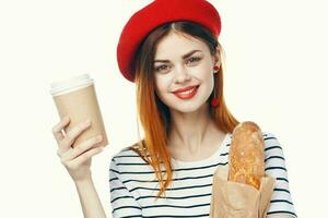 allegro donna con francese pagnotta e un' tazza di caldo bevanda buongustaio stile di vita foto