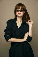 elegante donna rosso labbra occhiali da sole nero cappotto isolato sfondo foto