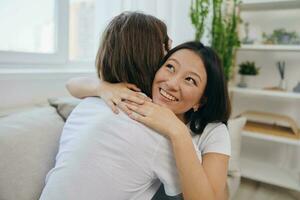 un asiatico donna abbracci sua marito e sorrisi. il gioia di utilizzando il famiglia e il bene psicologico stato dopo il litigare foto