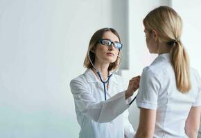 donna medico con stetoscopio e bicchieri esamina il paziente Salute modello foto