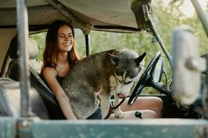 donna e sua rauco cane felicemente in viaggio nel auto Sorridi con denti autunno camminare con animale domestico, viaggio con cane amico foto