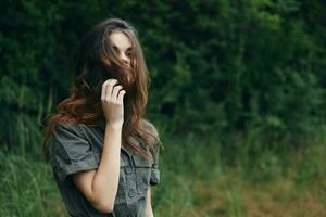 donna nel il foresta capelli coperture il viso verde alberi viaggio estate foto