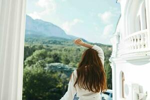 bellissimo donna sembra a un' bellissimo Visualizza a partire dal il balcone montagna Visualizza foto