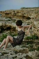 bellissimo donna seduta su il pietre paesaggio natura all'aperto foto