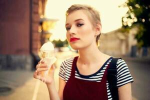 carino corto dai capelli donna all'aperto mangiare ghiaccio crema divertimento foto